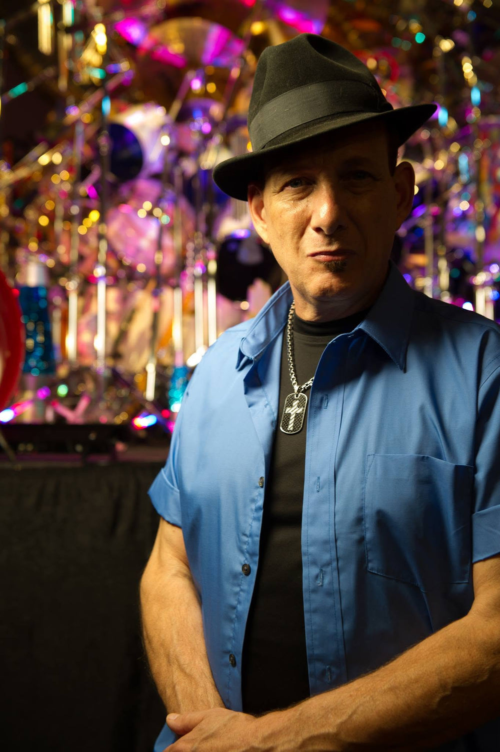Mark Temperato standing in front of his enormous drum set